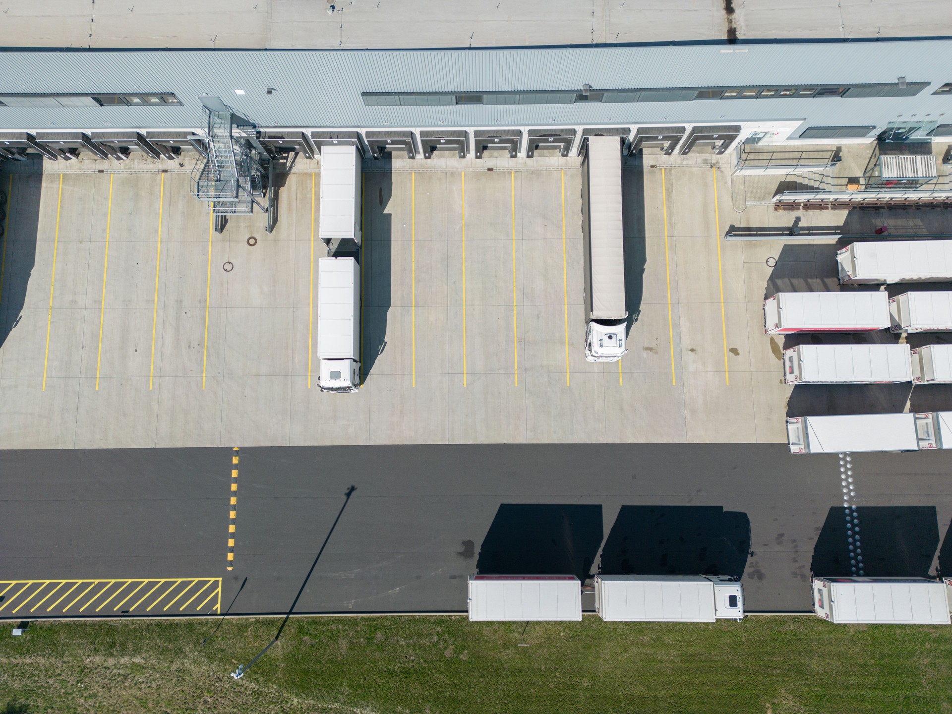 Aerial view of a large distribution warehouse with loading docks trucks